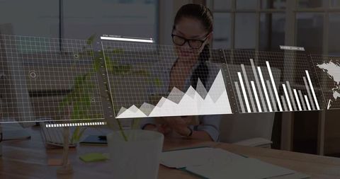 Asian businesswoman reviewing reports and mobile data analytics at modern office desk