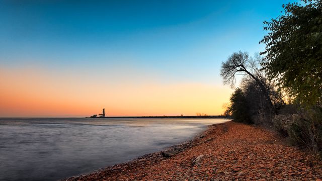 Serene Lakeside Sunset with Distant Lighthouse - Download Free Stock Photos Pikwizard.com