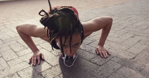 African american woman doing push-ups outdoors for fitness