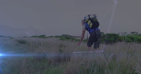 Senior Man Hiking Through Countryside with Backpack and Rolling Hilltops