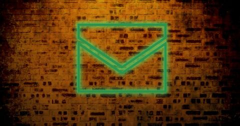Glowing neon envelope icon on grunge brick wall