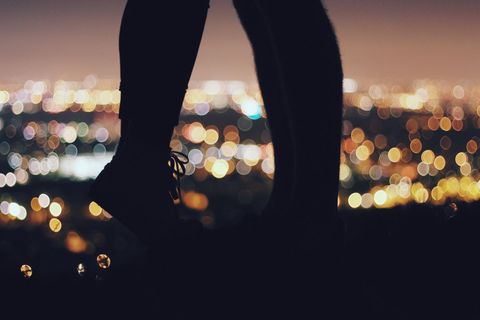 Silhouette of couple sharing intimate moment against blurred city lights backdrop, creating a romantic and dreamy ambiance. Perfect for representing romance, night outings, or scenic viewpoints. Can be used in advertisements for travel destinations, romantic getaways, or love-themed promotions.