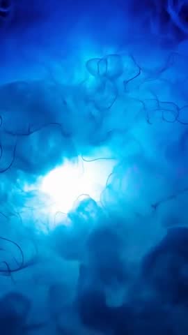 Cyan-Blue Core Emitting Turquoise Dye Plumes and Tendrils Diffusing in Vertical Macro