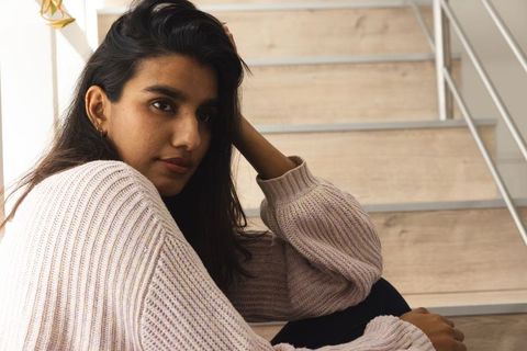 Thoughtful Woman Relaxing on Modern Staircase in Cozy Interior