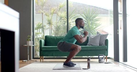 Man Performing Deep Squats in Stylish Living Room Home Workout