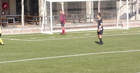 Juvenile Soccer Game with Red Uniformed Goalkeeper in action