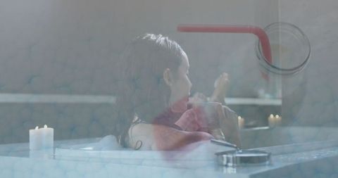 Serene Woman Relaxing in Bathtub with Candlelit Atmosphere