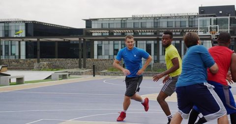Men playing pickup basketball outdoors on campus court