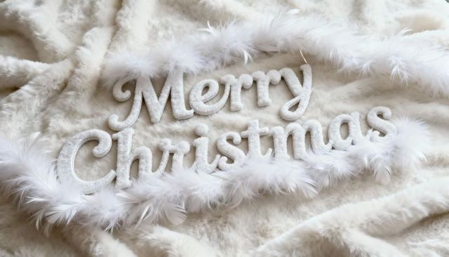 Merry christmas cursive sign on white faux fur with feather boa cozy holiday decor