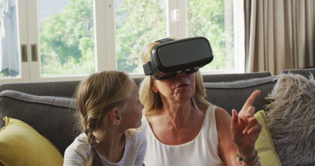 Senior Woman Using VR Headset with Curious Granddaughter - Download Free Stock Images Pikwizard.com