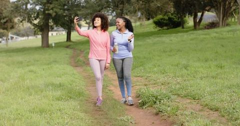Women Friends Walking and Taking Selfie on Park Trail in Activewear with Reusable Bottle