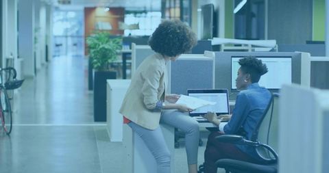 Collaborating Coworkers Reviewing Documents at Open-Plan Office Workstation with Laptop
