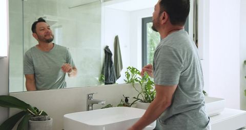 Man Grooming in Modern Bathroom with Plants Offering Tranquility