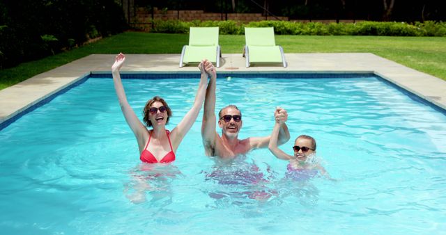 Happy family enjoying in swimming pool 