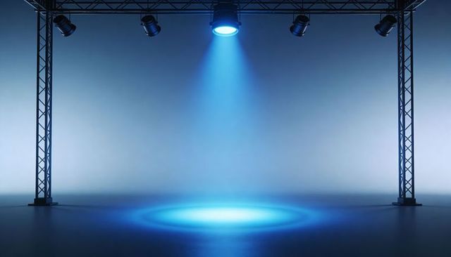 Cinematic Blue Spotlight Casting Circular Pool on Reflective Stage with Truss Lighting