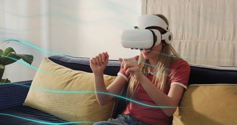 Young woman wearing VR headset interacting with holographic interface on living room couch