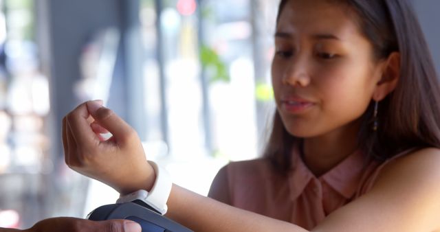 Woman Paying with Smartwatch at Cashless Payment Terminal - Download Free Stock Images Pikwizard.com