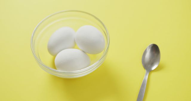 Three White Eggs in Glass Bowl with Spoon on Yellow Background - Download Free Stock Images Pikwizard.com