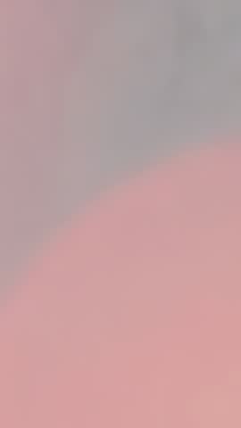Vertical gradient video transitioning soft pink to muted gray color field for modern backgrounds