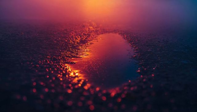 Vibrant Sunset Reflections on Gravel Pathway with Puddle