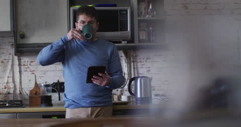 Man Leisurely Enjoying Coffee While on Smartphone at Home