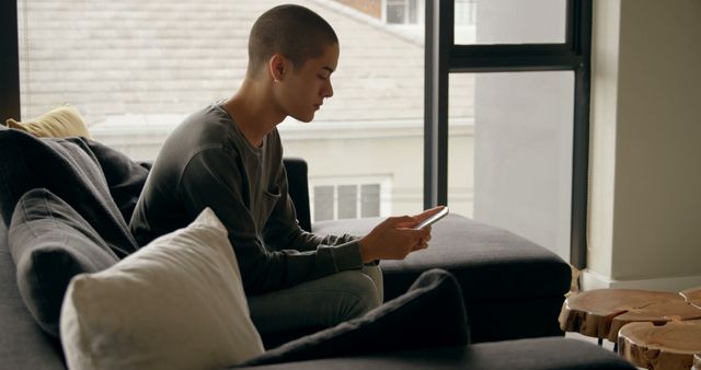 Person Sitting on Sofa and Using a Tablet in Modern Living Room - Download Free Stock Images Pikwizard.com