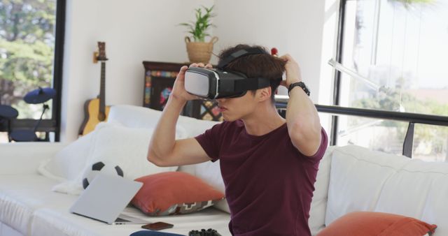 Young Man Using VR Headset on Sofa in Cozy Living Room - Download Free Stock Images Pikwizard.com