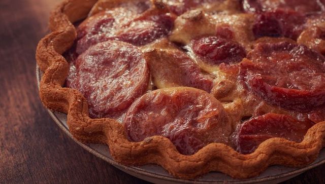 Freshly Baked Tart with Glazed Plum Slices in Rustic Setting