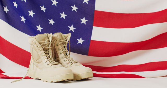 This powerful image of military boots placed in front of an American flag symbolizes patriotism, honor, and the sacrifices made by armed forces. Ideal for use in Veterans Day or Memorial Day promotions, social media posts honoring soldiers, or articles discussing military service and patriotism. Also useful for designs needing themes of freedom, national pride, and military service.