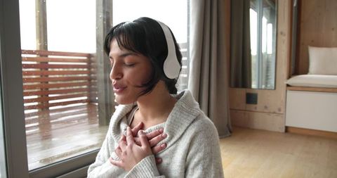 Woman embracing mindfulness by modern cabin window