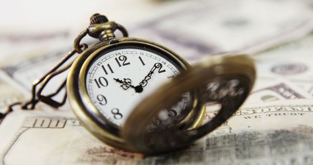 Depicts a vintage pocket watch placed on US dollar bills, symbolizing the relationship between time and money. Can be used for illustrating financial themes, investment opportunities, economic articles, wealth management tips, legacy planning concepts, and blog posts related to savings and time value of money.