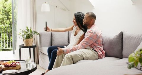 Happy Couple Sharing Engagement Announcement on Video Call