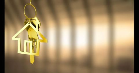 Golden house-shaped key ring with keys in urban corridor