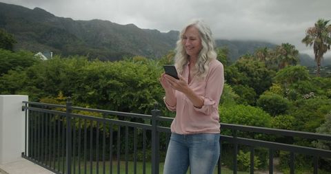 Joyful Woman on Balcony Embracing Technology’s Wonders