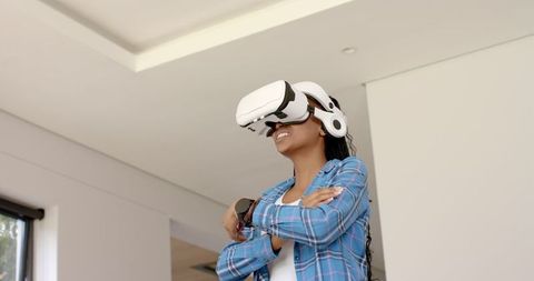 Joyful african american woman experiencing virtual reality at home