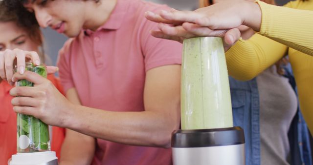 Group of friends enjoying making green smoothies together, using blenders. Ideal for healthy lifestyle promotions, social gatherings, kitchen appliances advertisements, and teamwork illustrations.