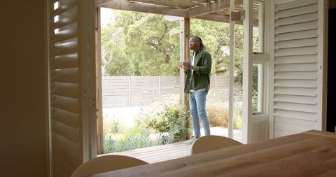 Man Enjoying Leisurely Moment on Wooden Deck at Home