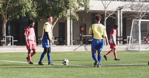 Teen Soccer Players Focused on Ball Control in School Match