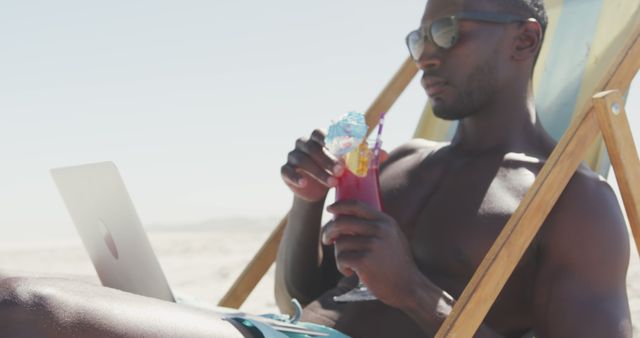 Relaxed Man Browsing Laptop and Drinking Cocktail at Beach - Download Free Stock Images Pikwizard.com