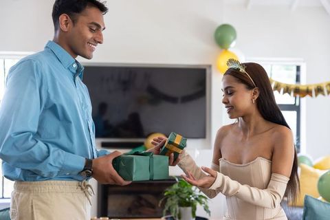 Couple exchanging gifts during festive celebration at home