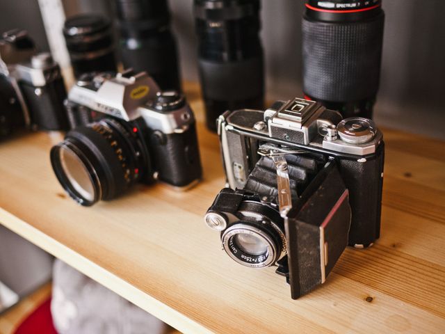 Capture attention with this image of vintage film cameras displayed on a wooden shelf. Ideal for blogs about photography history, retro technology enthusiasts, and vintage camera collectors. Perfect for illustrating articles on the evolution of photography or adding a nostalgic touch to social media posts about hobbies and passions.
