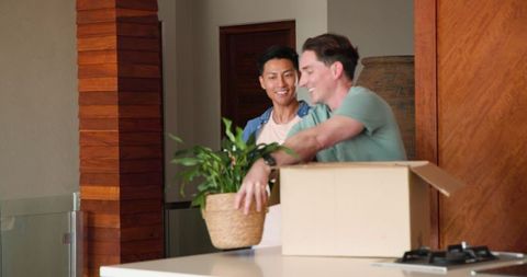 Happy Gay Couple Unpacking New Home Decor Together