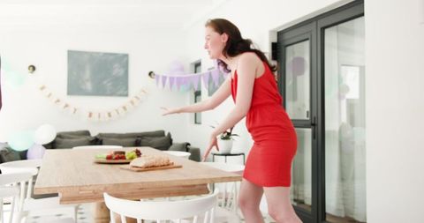 Woman Enthusiastically Decorating Table For Birthday Celebration Indoors