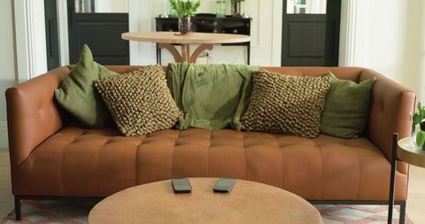 Tufted Brown Leather Sofa with Olive Green Cushions and Round Wood Coffee Table, Cozy Living Room