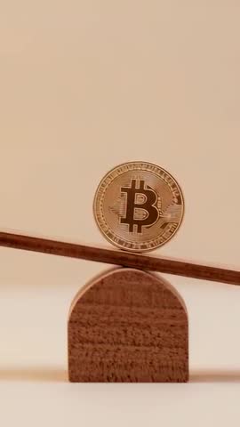 Tilting Plank Nudging Bronze Bitcoin on Wooden Fulcrum Representing Crypto Balance