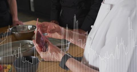 Chef showing poultry trim technique during culinary training, kitchen demonstration