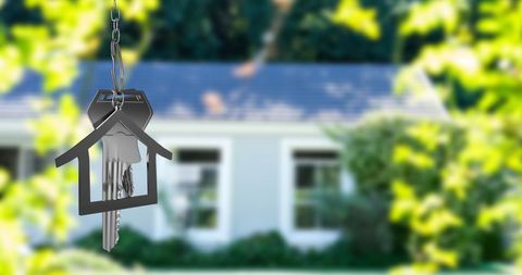 House Keys on Keychain Symbolizing Home Ownership Against Blurred Background