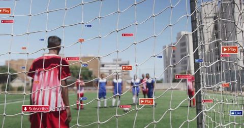 Youth soccer player watching action through goal net with social media icons play like