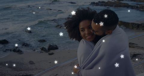 Romantic Couple Wrapped in Blanket by Ocean Under Stars