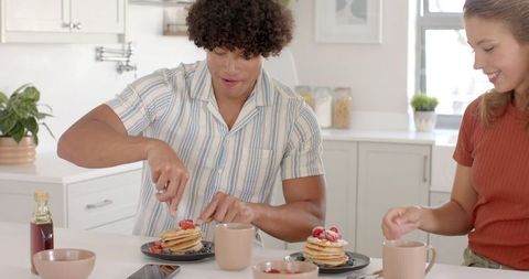 Smiling Couple Enjoying Breakfast Pancakes Together in Cozy Kitchen